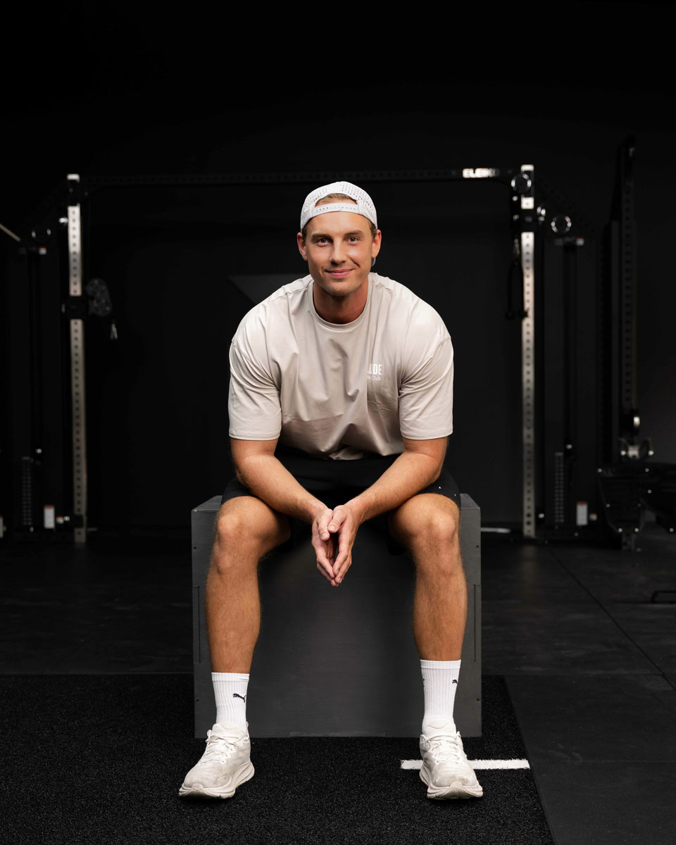 Tränaren ler medan han sitter på gymmet.